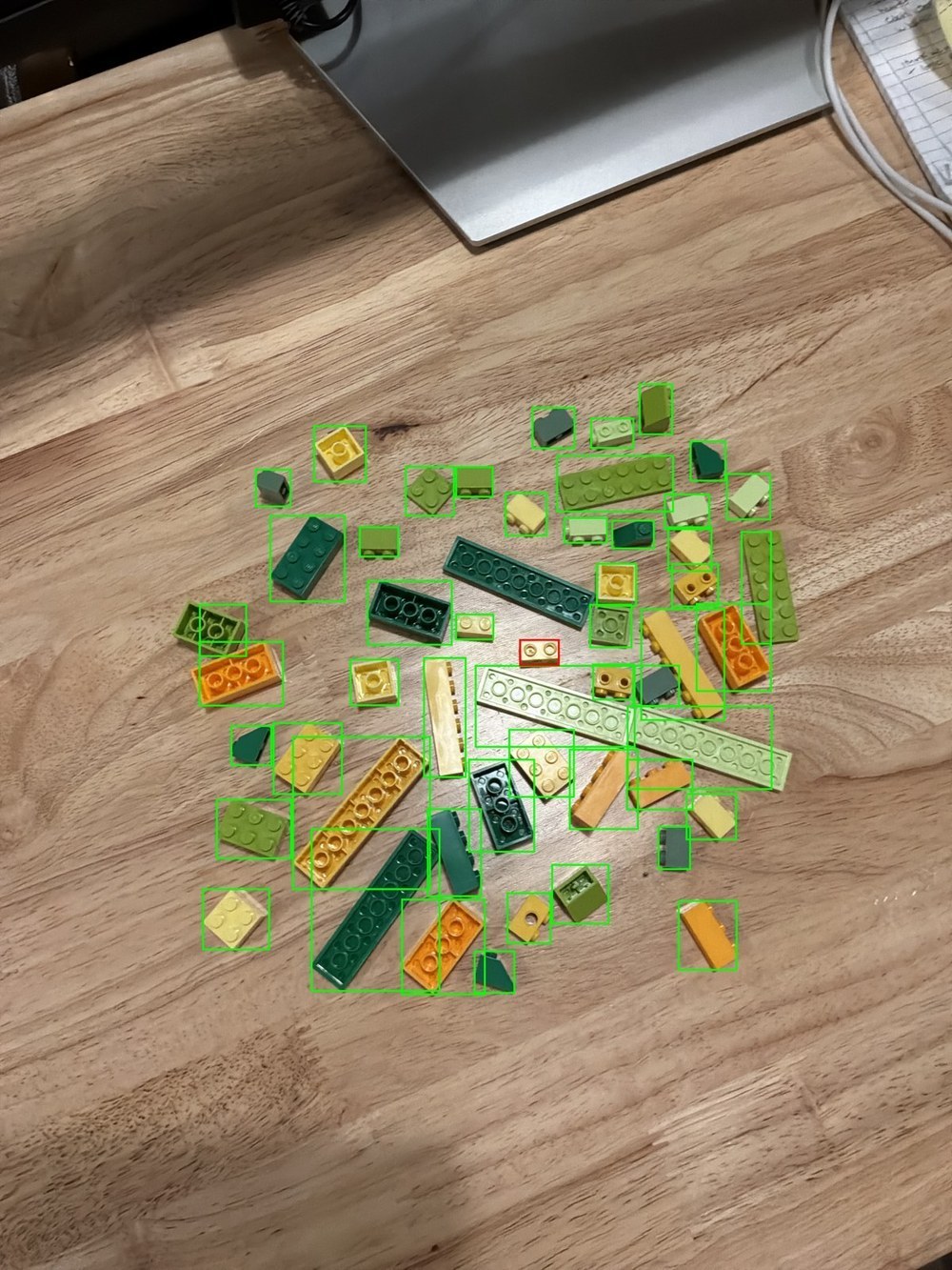 One real photograph of loose bricks with green detection boxes